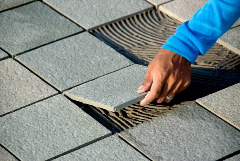 Man laying out some flooring material