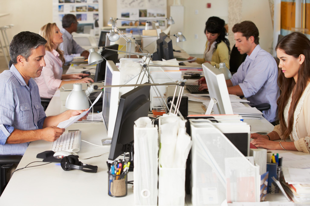 Team Working At Desks In Busy Office