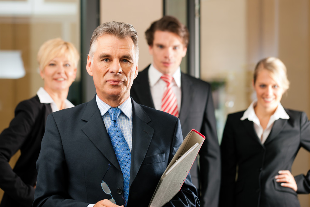 team in an office; the senior executive is standing in front