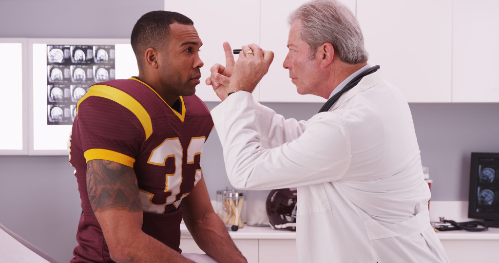 doctor checking athlete's eyes