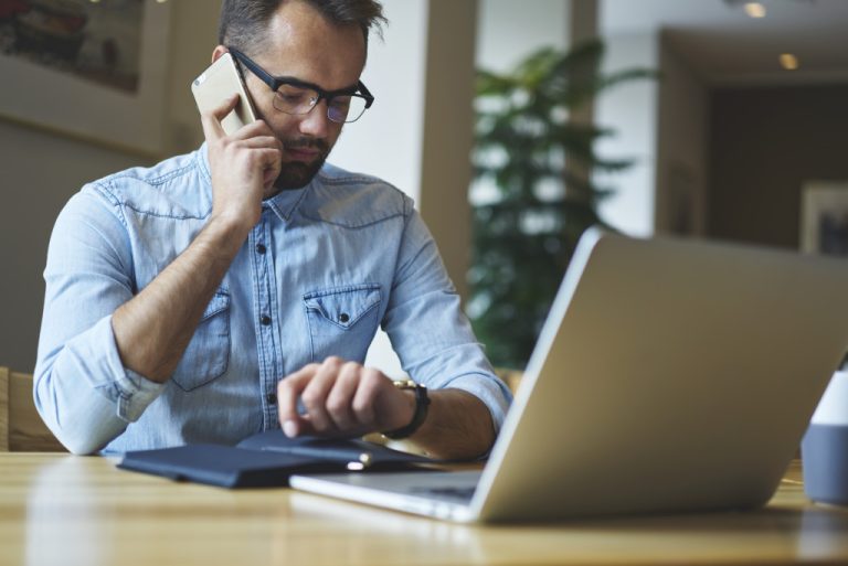 man calling while using laptop