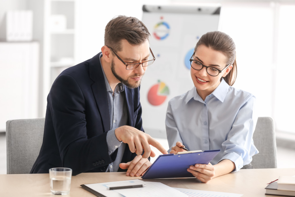 a businessman talking to a staff doing s review on a document