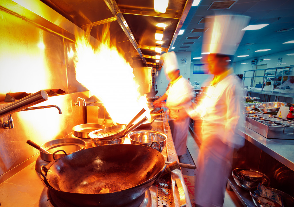 Chefs cooking with a wok in a restaurant